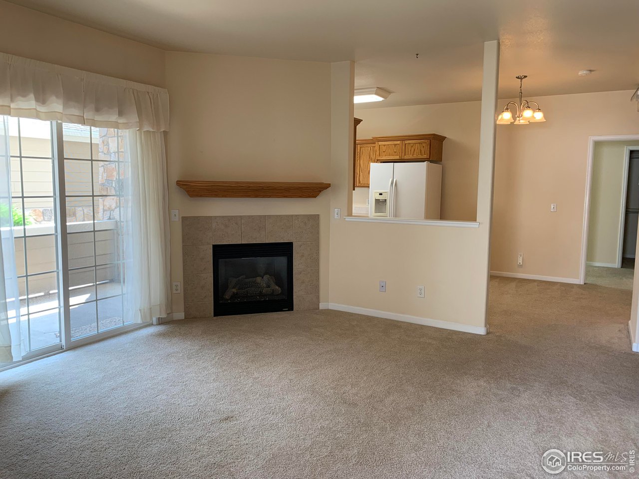 124 Beacon Way, Unit B Windsor, CO 80550 - Photo 1 of 26 a view of an empty room with a fireplace and a window