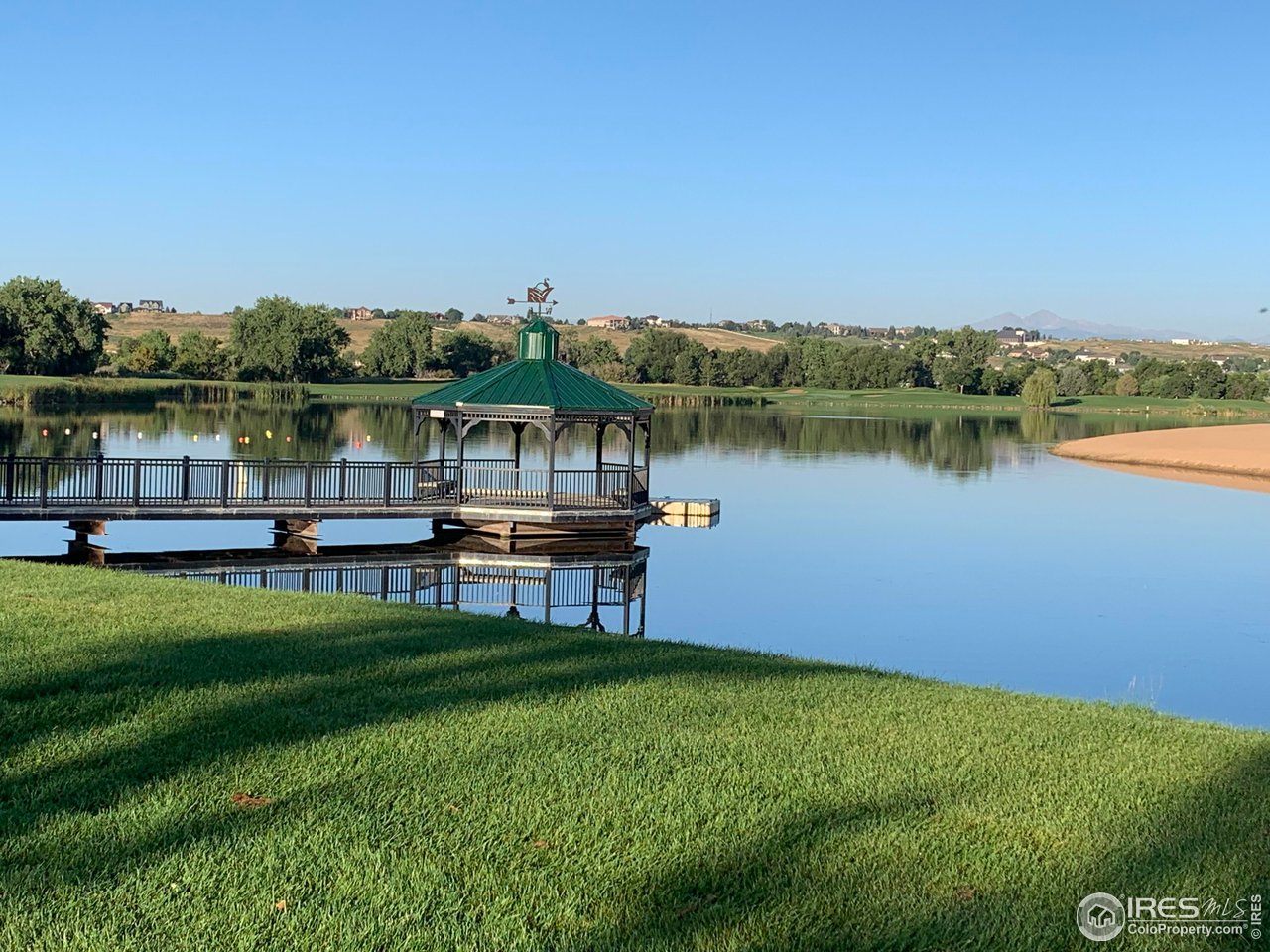 124 Beacon Way, Unit B Windsor, CO 80550 - Photo 20 of 26 a view of a lake with houses in the back