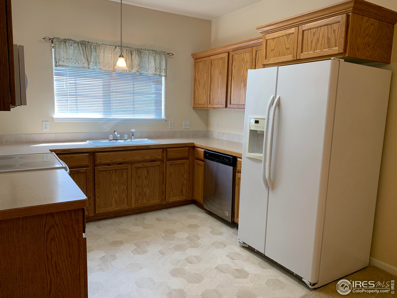 124 Beacon Way, Unit B Windsor, CO 80550 - Photo 5 of 26 a kitchen with stainless steel appliances a sink cabinets and a refrigerator