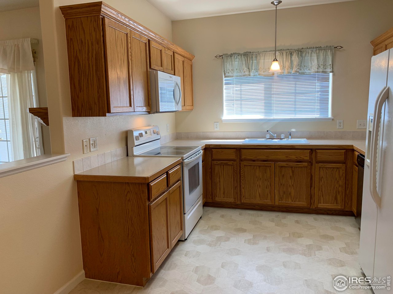 124 Beacon Way, Unit B Windsor, CO 80550 - Photo 6 of 26 a kitchen with stainless steel appliances a sink stove and cabinets