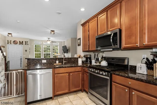 a kitchen with granite countertop a sink stainless steel appliances and cabinets