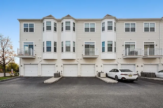 a couple of cars parked in front of a white house