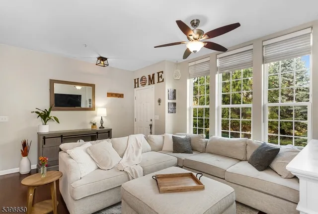 a living room with furniture a large window and a flat screen tv