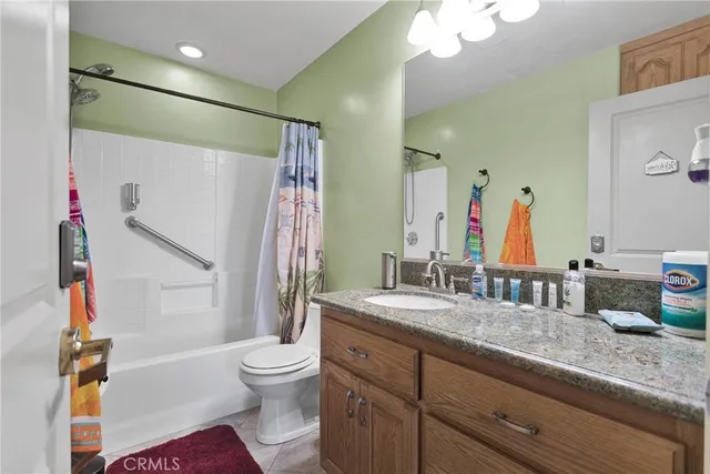 a bathroom with a granite countertop sink toilet mirror and shower