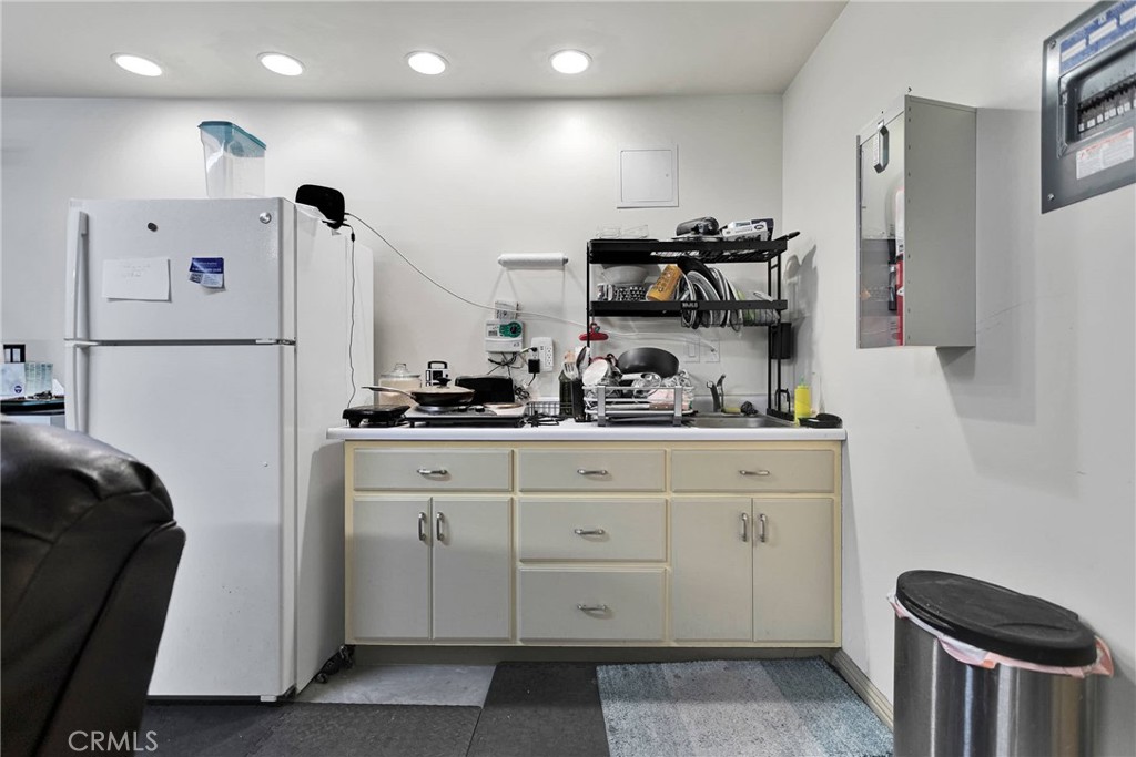 32758 Spinel Road Lucerne Valley, CA 92356 - Photo 26 of 40 a kitchen with stainless steel appliances kitchen island granite countertop a refrigerator a stove a sink and white cabinets with wooden floor