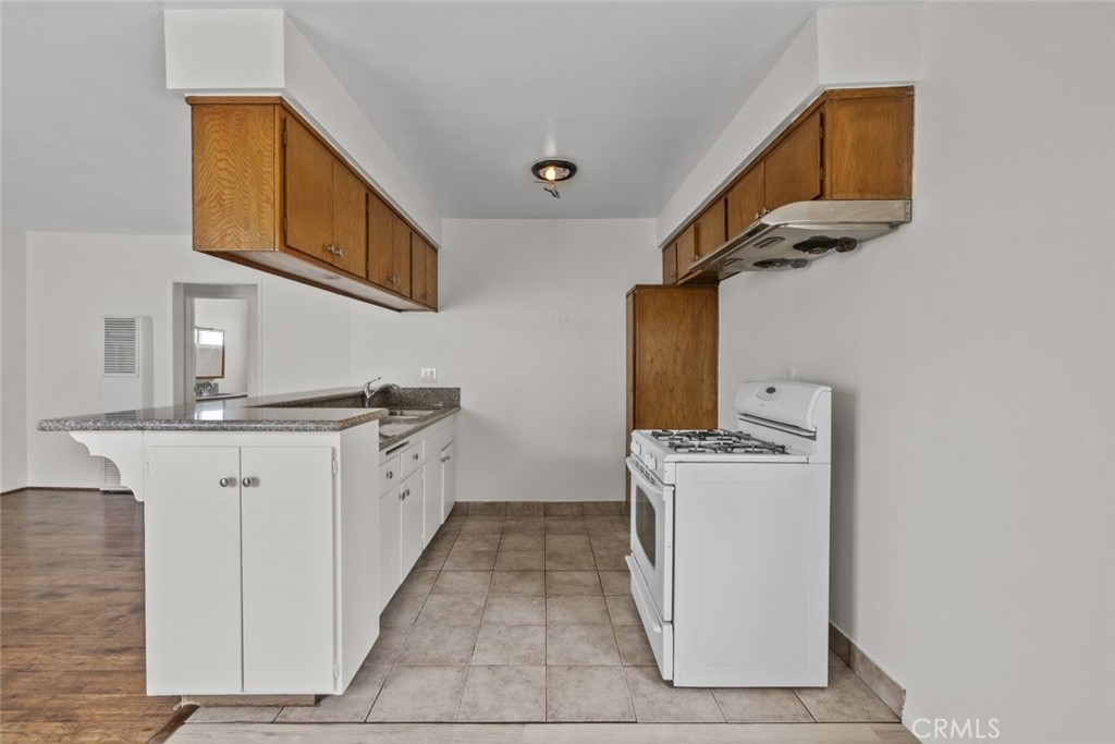 1601 College View Drive, Unit 12 Monterey Park, CA 91754 - Photo 12 of 27 a kitchen with a stove top oven cabinets and a refrigerator