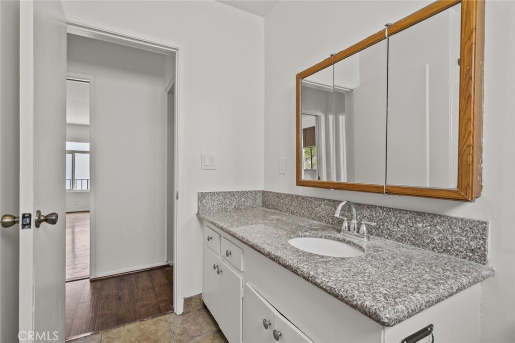 1601 College View Drive, Unit 12 Monterey Park, CA 91754 - Photo 22 of 27 a bathroom with a granite countertop sink and a mirror