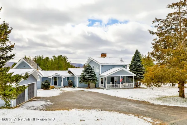 a view of a dining room with furniture wooden floor a rug and a large window