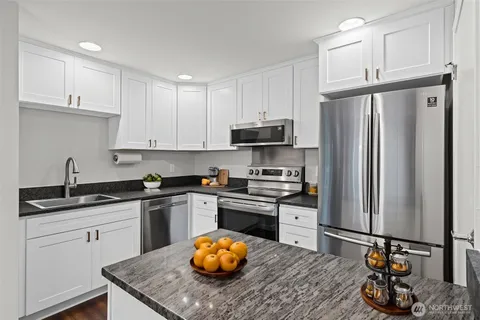 a kitchen with stainless steel appliances granite countertop a sink stove and refrigerator