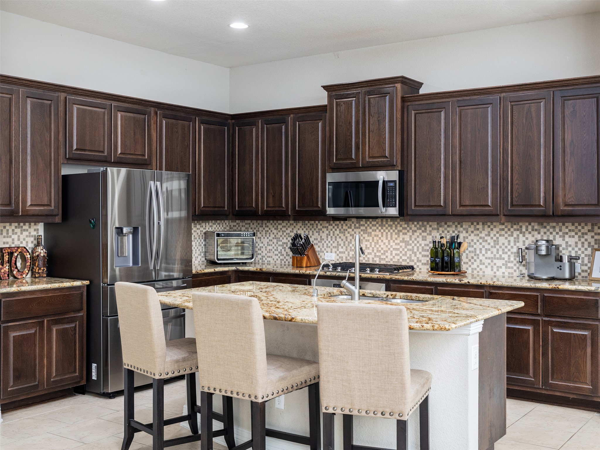 717 Blue Agave Lane Georgetown, TX 78626 - Photo 9 of 28 a kitchen with stainless steel appliances granite countertop a table chairs microwave and sink