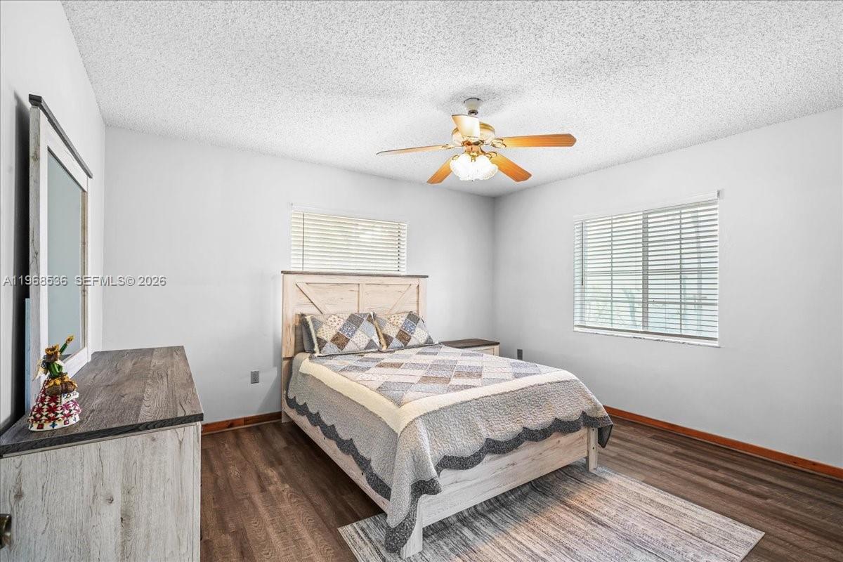 17490 Southwest 288th Street Homestead, FL 33030 - Photo 6 of 80 a bedroom with a bed and a chandelier