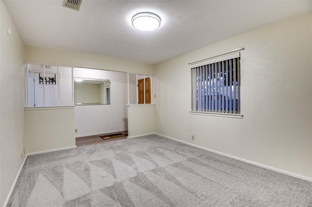 802 Cardinal Road Mansfield, TX 76063 - Photo 10 of 31 Empty room featuring light colored carpet and a textured ceiling