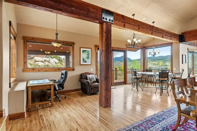 a dining room with wooden floor glass table and chairs