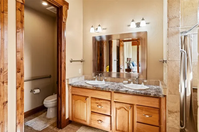 a bathroom with a granite countertop sink toilet and shower