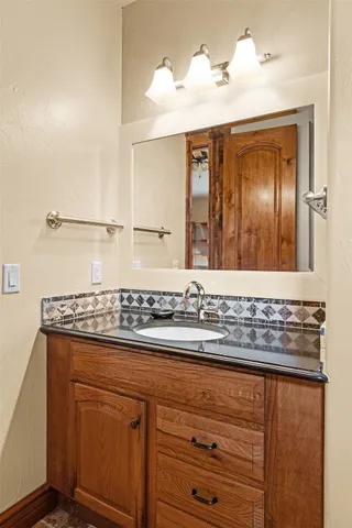 a bathroom with a granite countertop sink and a mirror