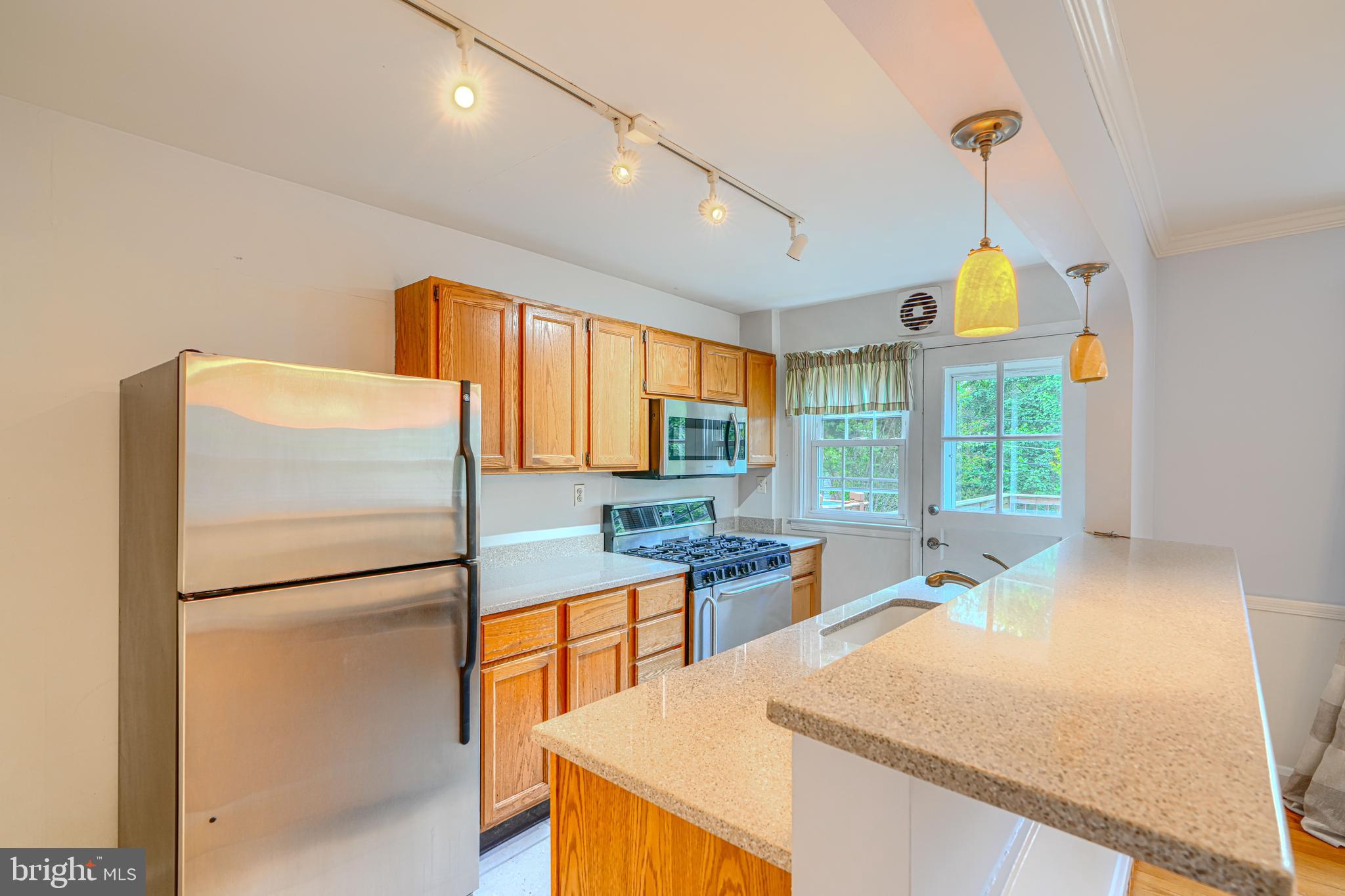 372 Old Trail Baltimore, MD 21212 - Photo 9 of 46 a kitchen with stainless steel appliances granite countertop a refrigerator a sink dishwasher a stove and a dining table with wooden floor
