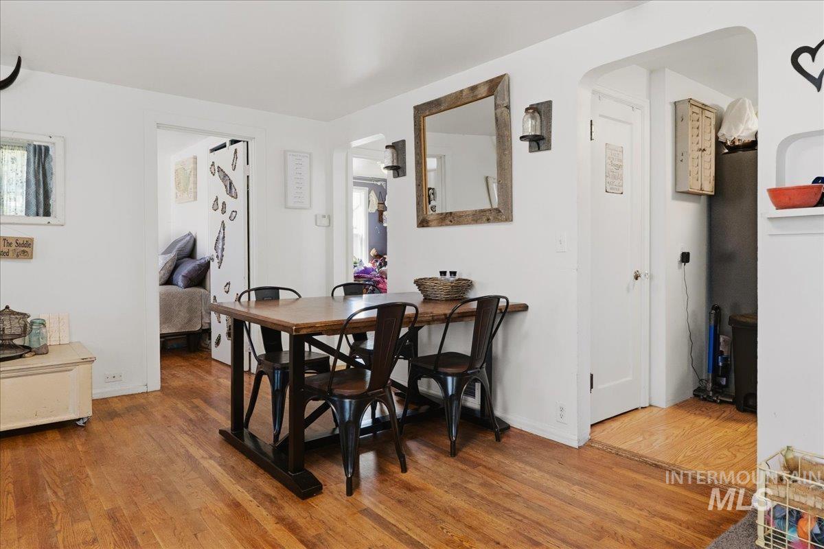 1958 East 1775 South Gooding, ID 83330 - Photo 12 of 49 Hardwood-finish flooring throughout, featuring a natural wood-toned dining table and white painted walls