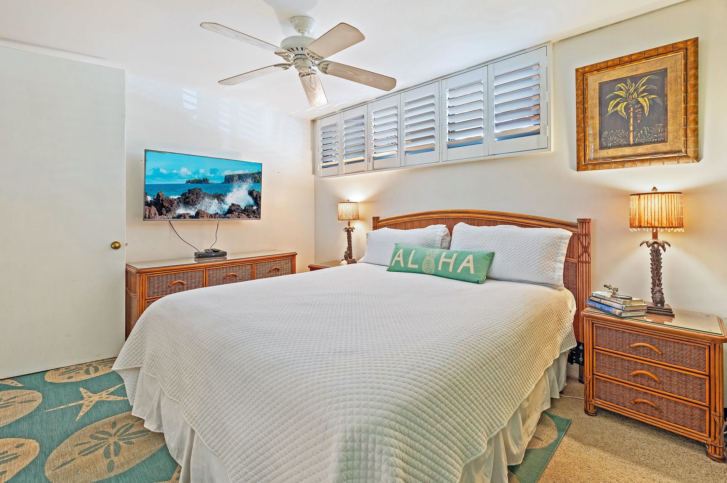 3543 Lower Honoapiilani Road, Unit H201 Lahaina, HI 96761 - Photo 23 of 31 a bedroom with a bed and a chandelier