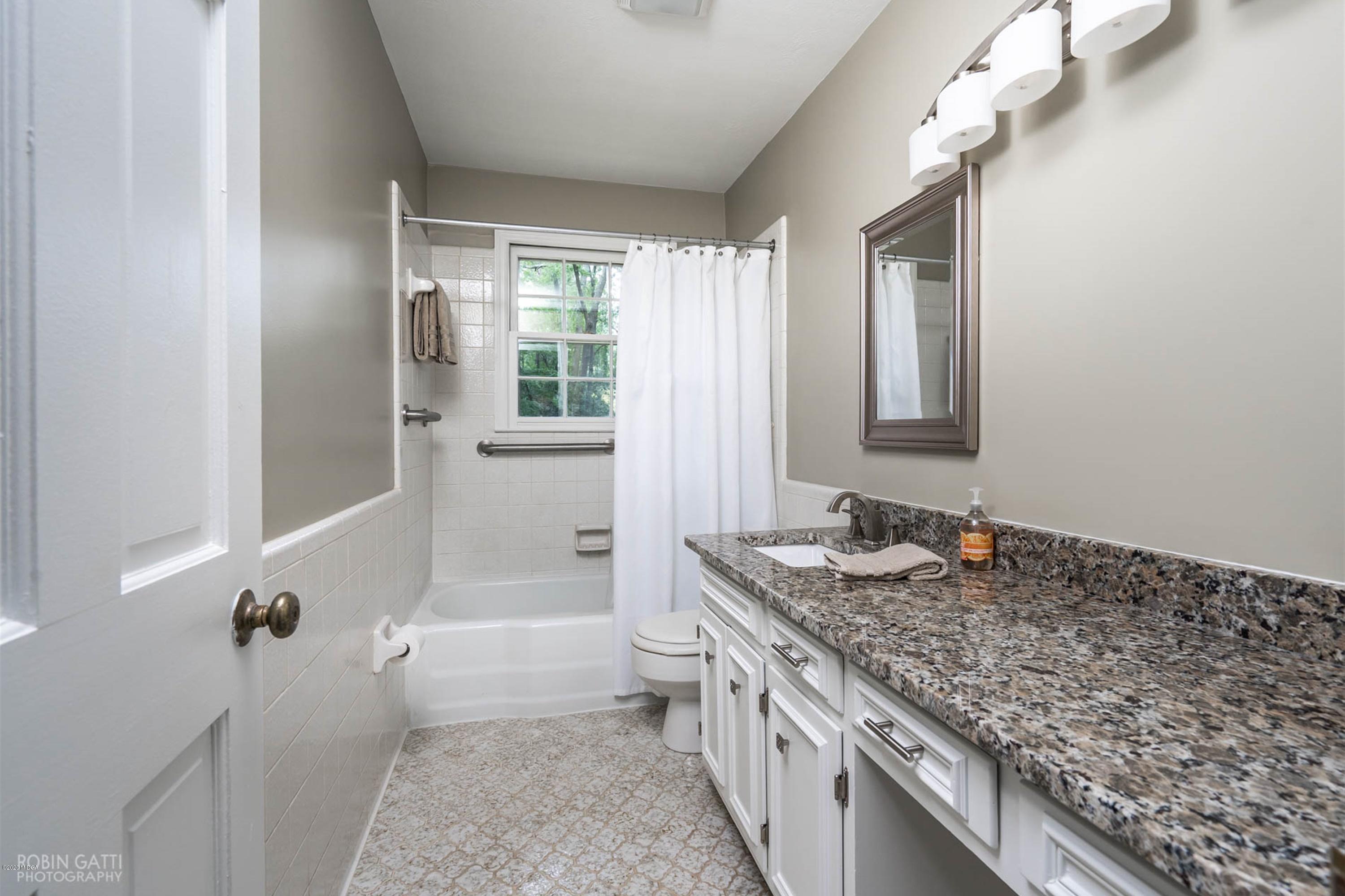5435 Riverside Drive Macon, GA 31210 - Photo 22 of 34 a bathroom with a granite countertop sink and mirror with bathtub