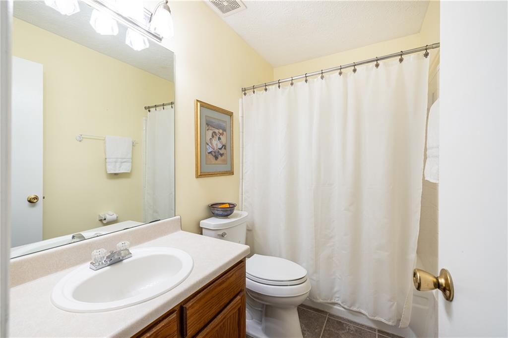 7750 Roswell Road, Unit 9G Sandy Springs, GA 30350 - Photo 15 of 18 a bathroom with a sink a toilet and shower curtain