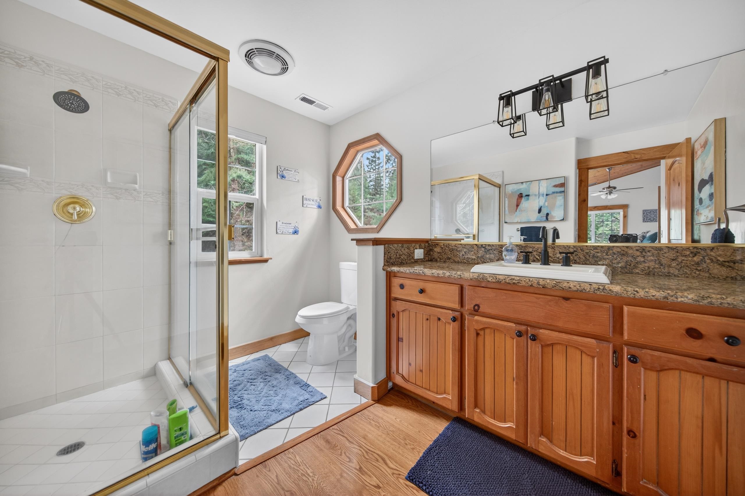 1220 Lynx Road Lake Almanor, CA 96137 - Photo 26 of 45 a spacious bathroom with a granite countertop sink mirror vanity and toilet