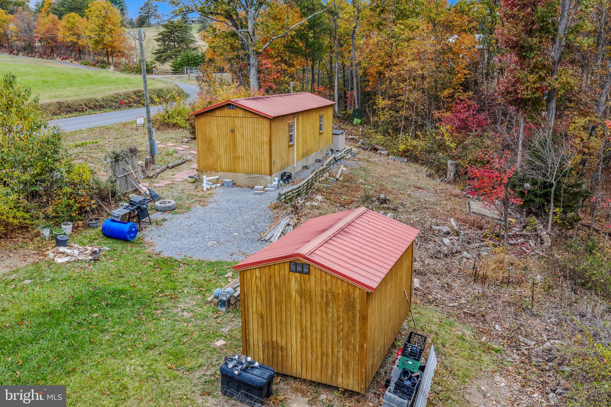 393 Ridersville Road Berkeley Springs, WV 25411 - Photo 21 of 32 a view of a backyard with plants and a bench