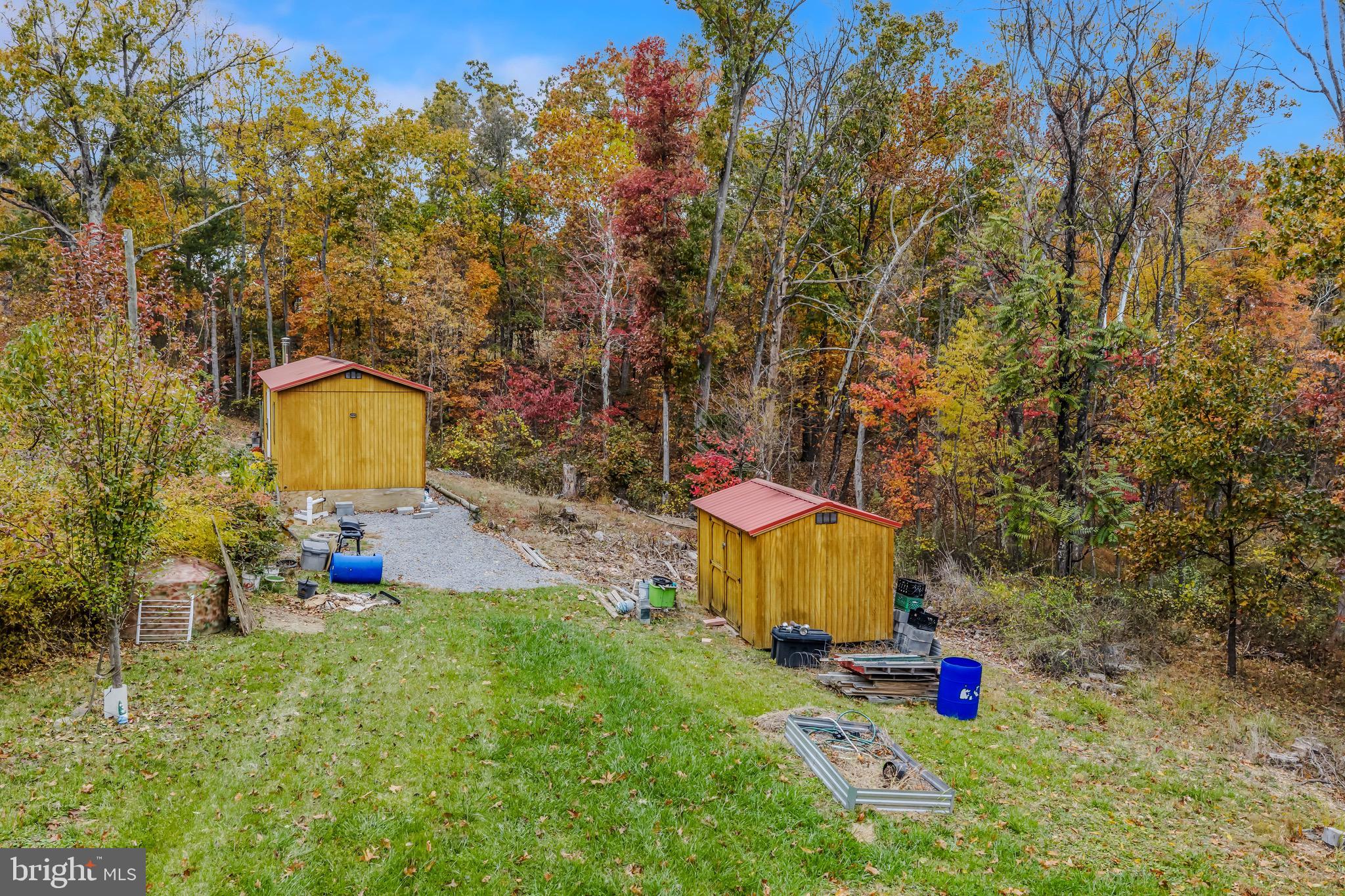 393 Ridersville Road Berkeley Springs, WV 25411 - Photo 22 of 32 a view of a backyard with table and chairs and a large tree