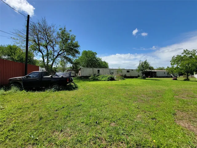 a view of backyard with huge green area and covered with tall trees