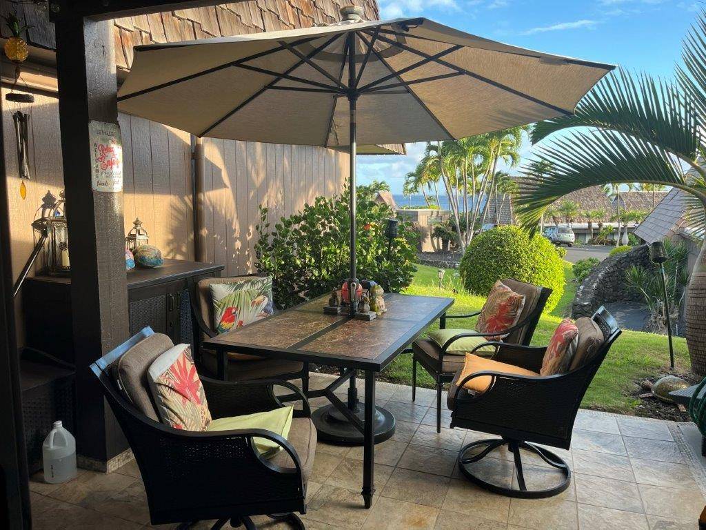 a view of an outdoor sitting area with furniture and umbrella