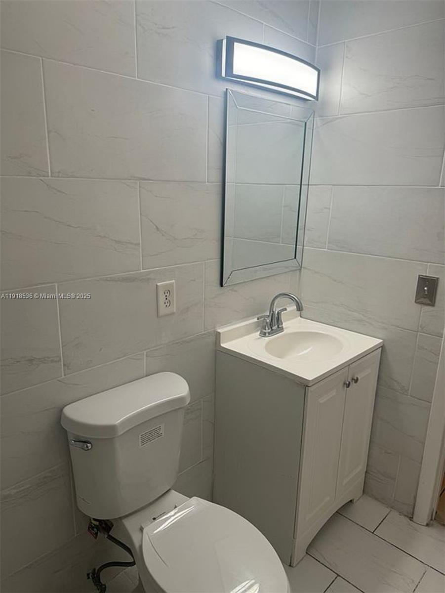 9453 Southwest 76th Street, Unit S7 Miami, FL 33173 - Photo 3 of 12 a bathroom with a toilet sink and mirror
