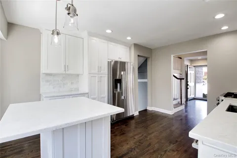a kitchen with stainless steel appliances a refrigerator and wooden floor