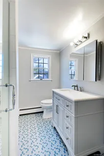 a bathroom with a sink a toilet and mirror