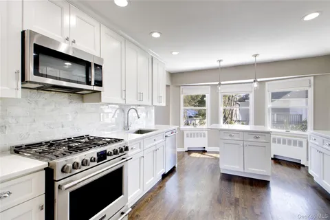 a large kitchen with stainless steel appliances granite countertop a stove and a microwave