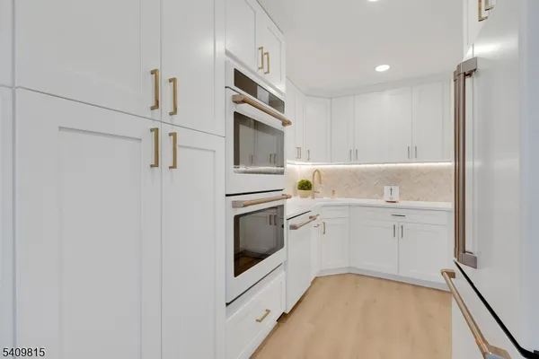 a kitchen with white cabinets and white appliances