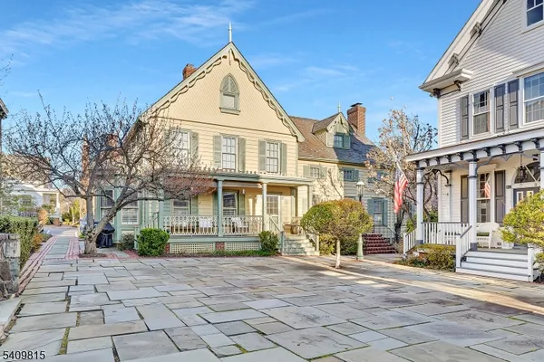 a view of a brick house with a yard and plants