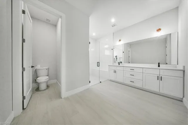 a spacious bathroom with a double vanity sink toilet and shower