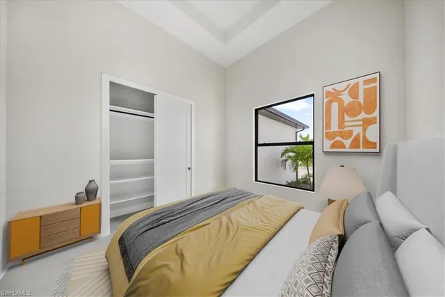 a bedroom with a bed couch and mirror