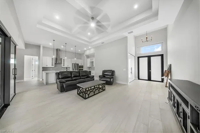 a living room with furniture white walls and kitchen view