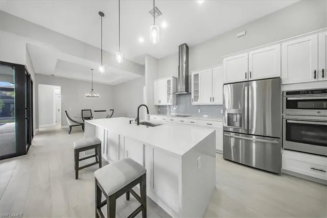 a kitchen with refrigerator and chairs