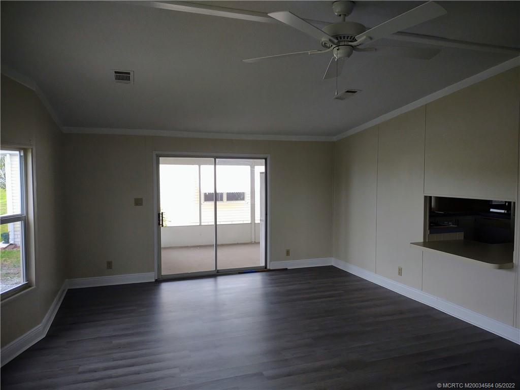 524 Thames Bluff Ridge, Unit D18 Fort Pierce, FL 34982 - Photo 12 of 24 an empty room with wooden floor fan and windows