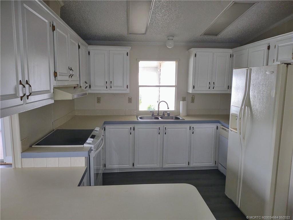 524 Thames Bluff Ridge, Unit D18 Fort Pierce, FL 34982 - Photo 14 of 24 a kitchen with white cabinets and a refrigerator