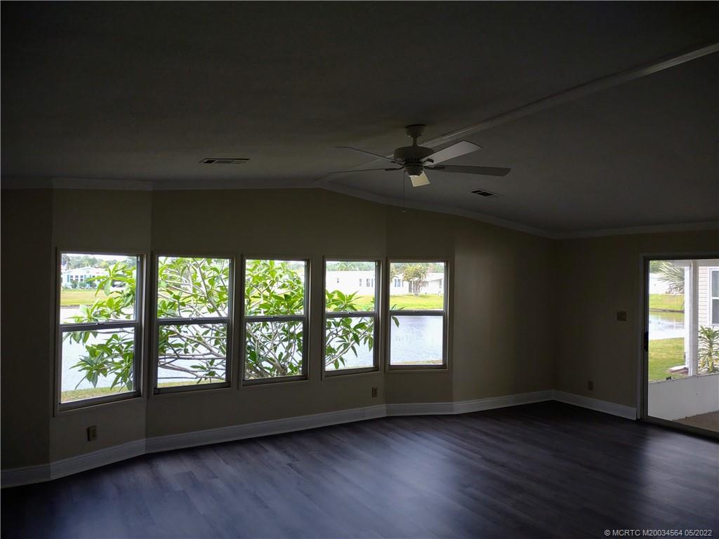 524 Thames Bluff Ridge, Unit D18 Fort Pierce, FL 34982 - Photo 10 of 24 an empty room with wooden floor chandelier fan and windows