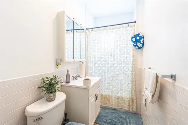 a bathroom with a sink a toilet and shower curtain
