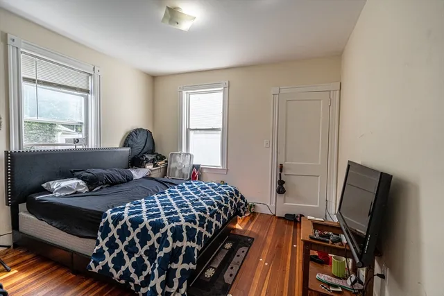 a bedroom with a bed and wooden floor