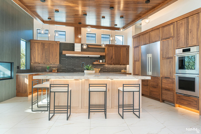 3607 South Cypress Pt Road Hurricane, UT 84737 - Photo 20 of 59 Kitchen with a kitchen breakfast bar with undercounter lighting, wood finish cabinets, stainless steel double oven, and wood drop ceiling