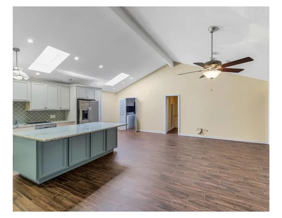 a view of kitchen with sink refrigerator and cabinets