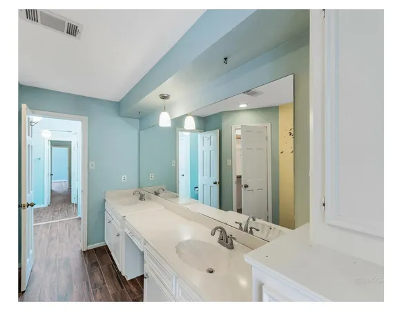 a spacious bathroom with a shower sink and mirror