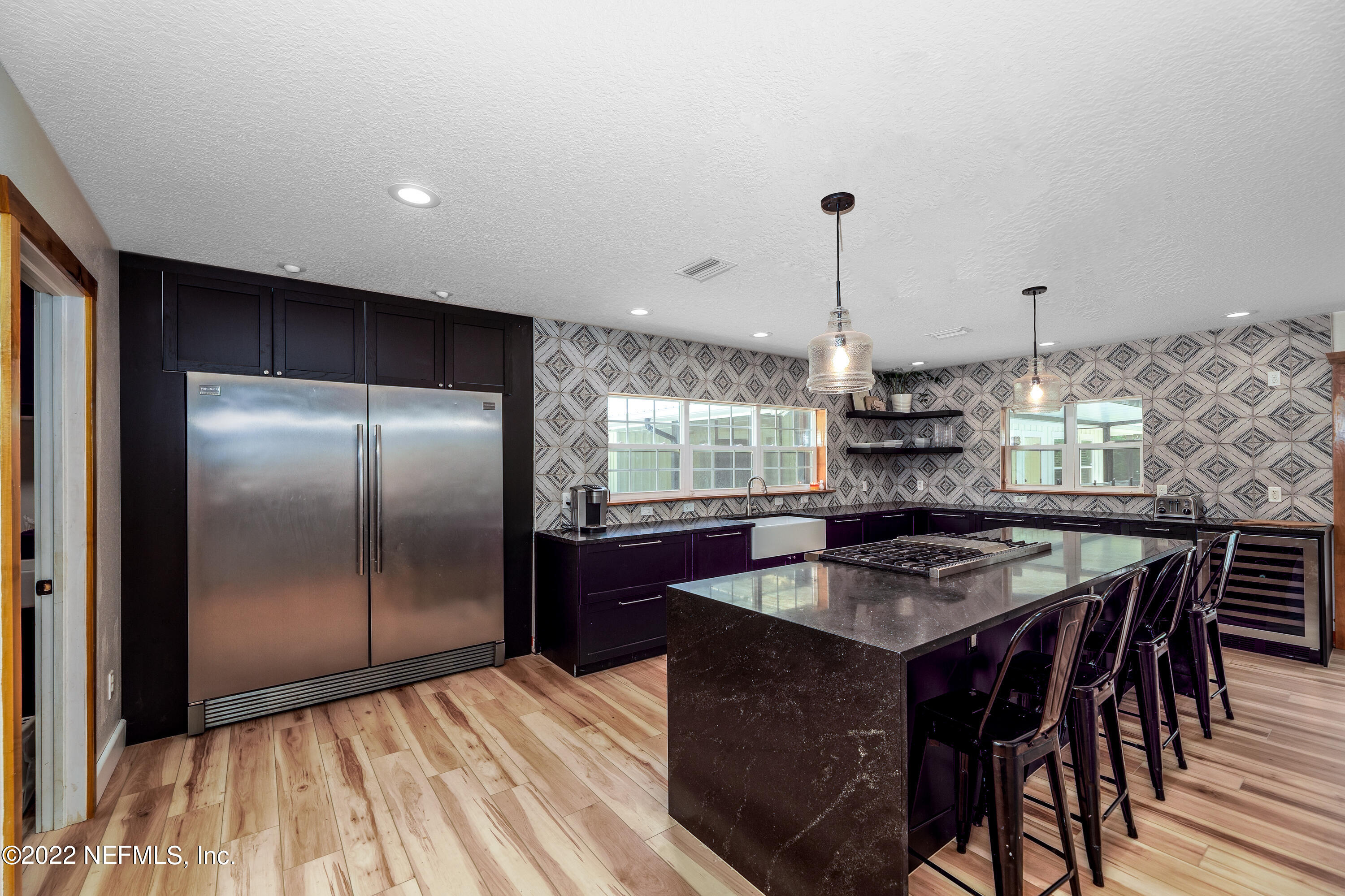 541 Federal Point Road East Palatka, FL 32131 - Photo 16 of 75 a kitchen with stainless steel appliances granite countertop a stove a refrigerator a sink a dining table and chairs with wooden floor