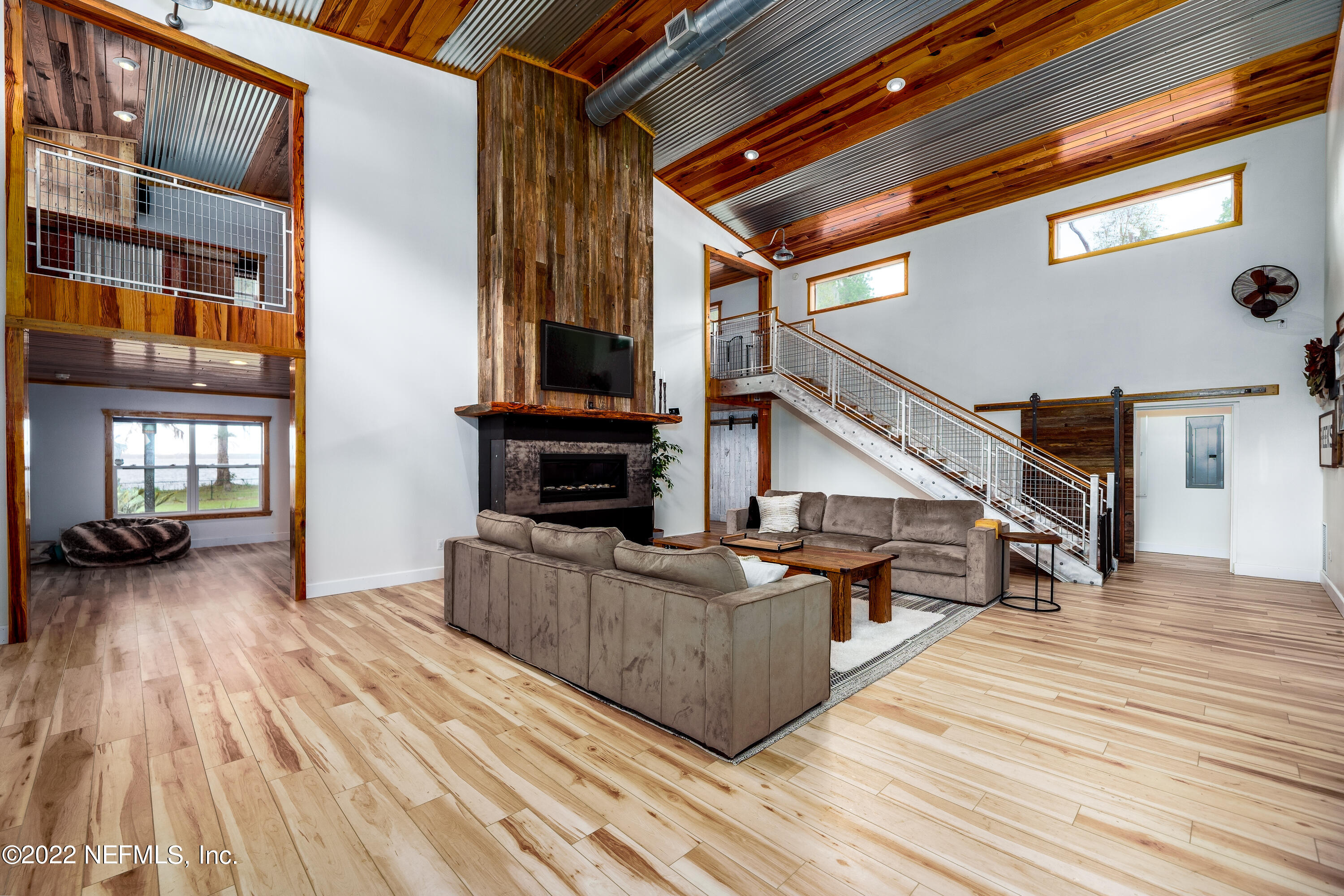 541 Federal Point Road East Palatka, FL 32131 - Photo 9 of 75 a view of a living room and kitchen with furniture wooden floor and windows