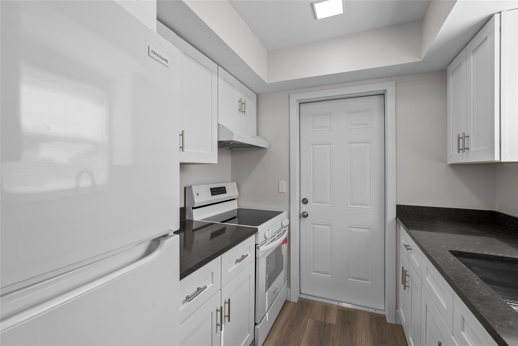 1150 East Sample Road, Unit 202 Pompano Beach, FL 33064 - Photo 4 of 20 a kitchen with granite countertop white cabinets and white appliances